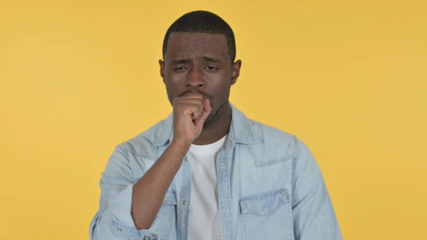 istock Sick Young African Man Coughing, Yellow Background 1328476758