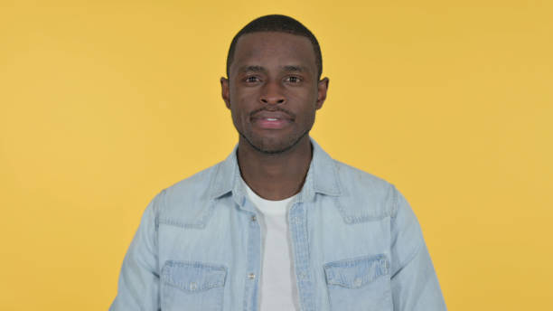 istock Young African Man Looking at Camera, Yellow Background 1328477747