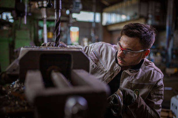 istock Engineer and milling machine operator, observing the work of the machine, making sure everything is fine 1328479141