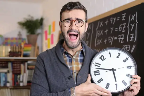 Photo of Teacher holding large clock in classroom