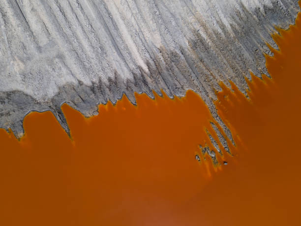 Orange red water on the titanium mine. Industrial background. Water pollution stock photo