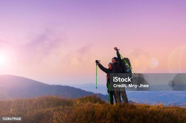 Hiker Couple With Backpacks Meets Sunset On The Mountain Top Active Lifestyle And Wanderlust Concept Stock Photo - Download Image Now