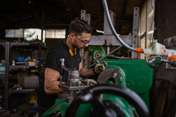 istock Engineer, making few adjustments to milling machine at the metal factory 1328479699