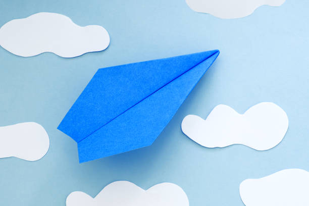 istock blue paper airplane and clouds, on a blue background 1328479845