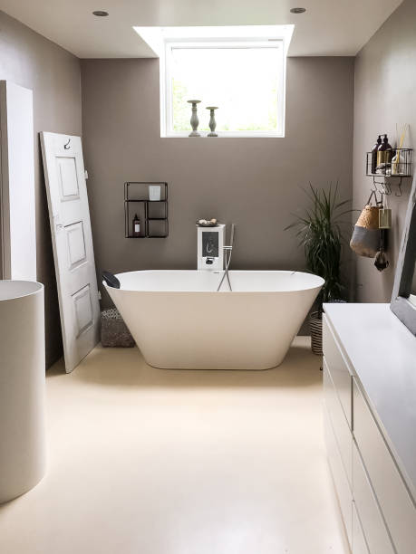 istock Minimalist bathroom interior with bath tube under small window 1328480790