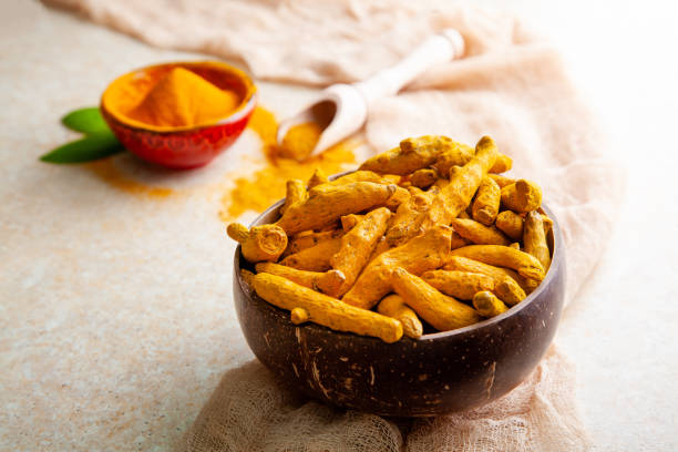 istock Dried turmeric roots in coconut shell bowl and powder with leaves 1328485065