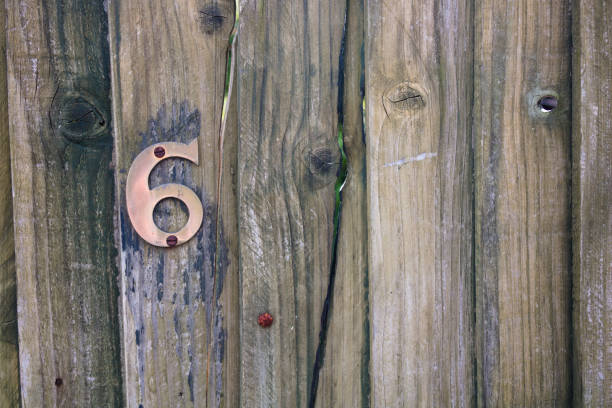 istock Brass number six on old wooden gate 1328485310