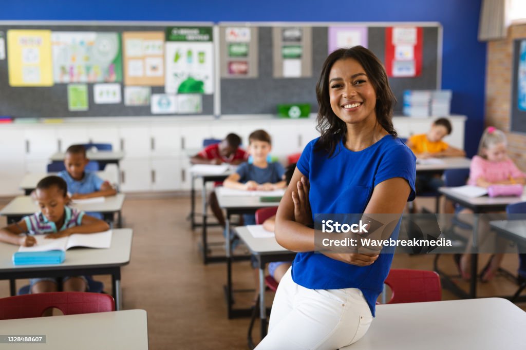 Portrait of african american female teacher smiling in the class at school Portrait of african american female teacher smiling in the class at school. school and education concept Teacher Stock Photo