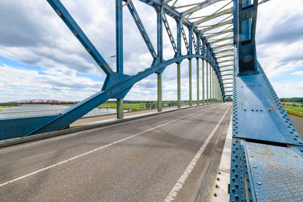 Old IJsselbrug over the river IJssel between Zwolle and Hattem. View from the middle of the road on the old steel arch bridge.