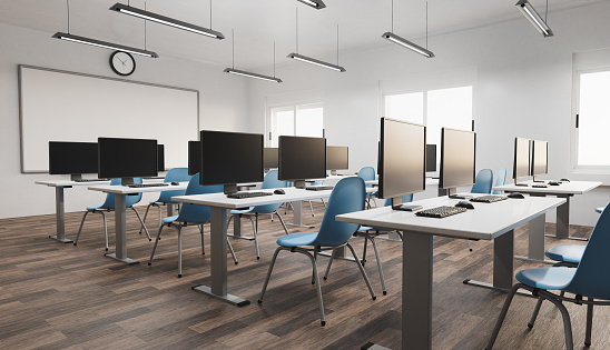 side view of a modern classroom with computers and luminous windows in the background. concept of education, back to school and technology. 3d render