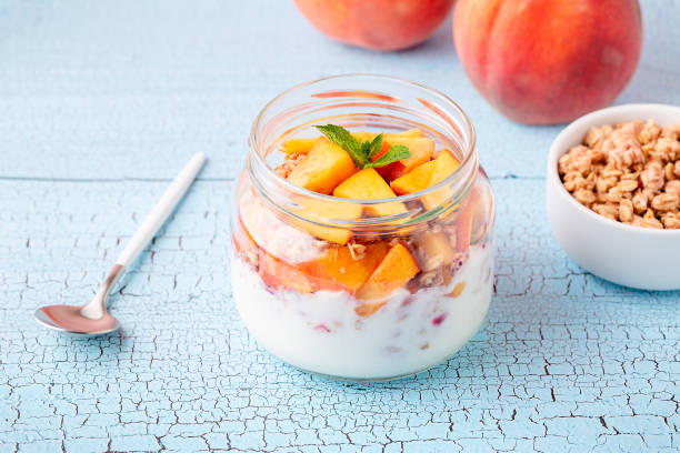 Healthy breakfast. Granola / muesli yoghurt and fruit served in glass jars stock photo
