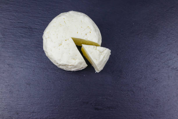 istock Soft Adyghe cheese on black slate background. Top view 1328491561