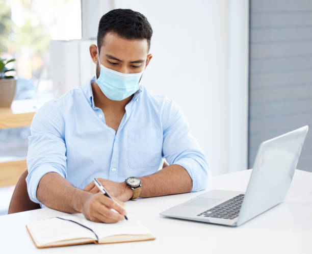 istock Shot of a young businessman writing in a notebook at work 1328492632
