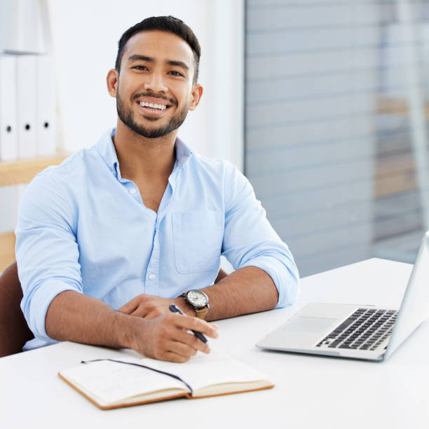 istock Shot of a young businessman writing in a notebook at work 1328492635