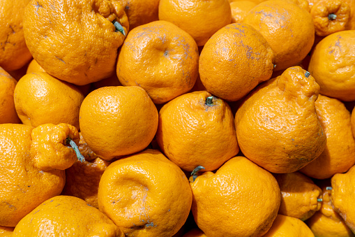 Peeled tangerines on a black background. Slices of tangerine or mandarin fruit close up.