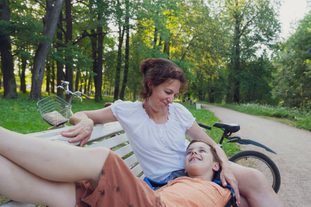 istock A woman and a boy relax on a park bench 1328493250