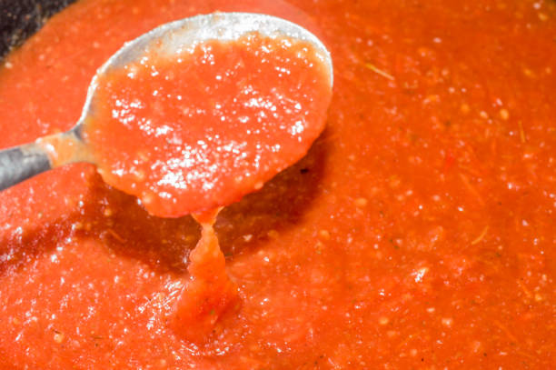 istock tomato sauce in a frying pan with spoon, dark background and copy space 1328494006