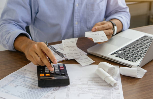 istock The office man calculate bills with using calculator in home office. financial concept. 1328496711