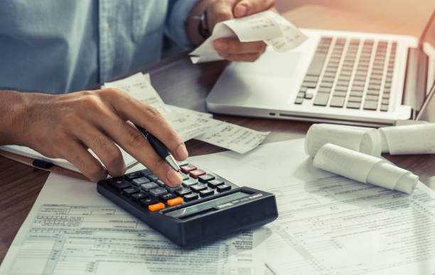istock The office man calculate bills with using calculator in home office. financial concept. 1328497772