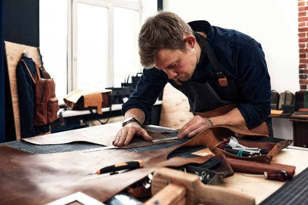 artesanos de cuero que trabajan haciendo measupenets en patrones en la mesa en el estudio del taller - artesano fotografías e imágenes de stock