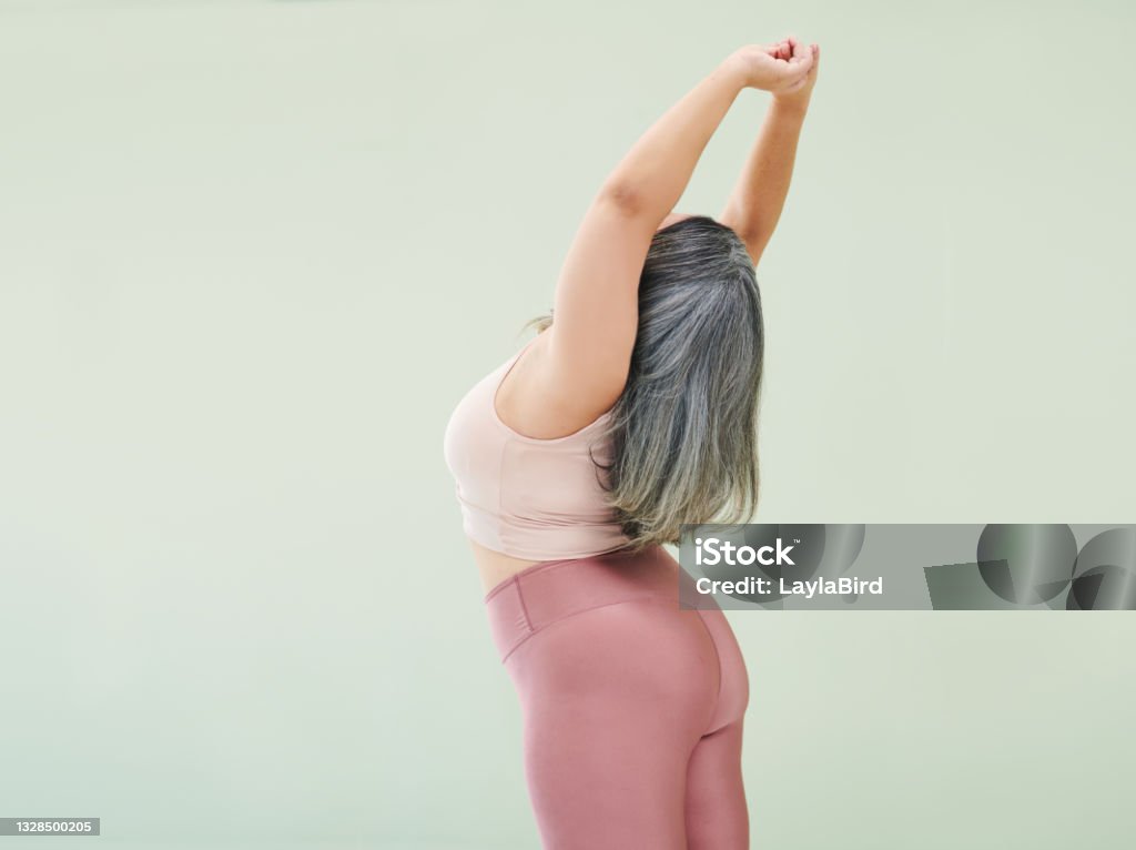 Rear studio shot of an unrecognizable woman stretching against a green background Honey, there's no time Women Stock Photo