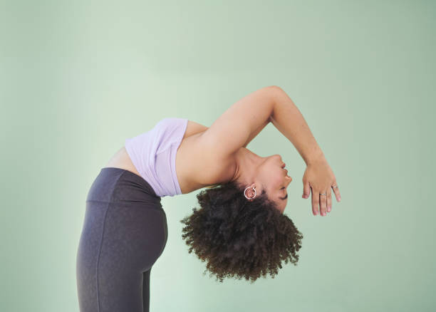Studio shot of a young woman bending over backwards against a green background Ivy climbs my walls, Heather in the fall plus size photos stock pictures, royalty-free photos & images