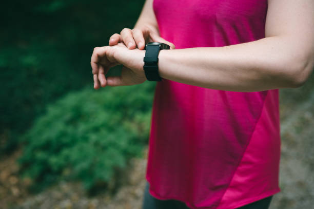 istock Sportswoman setting up smartwatch in a forest 1328501810