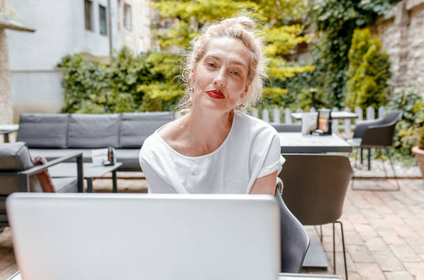 istock Smiling senior woman sitting in coffee shop using laptop. 1328501858