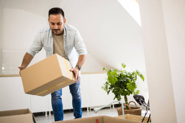istock Young man bringing boxes with belongings into his new apartment 1328503354