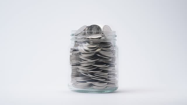 Time Lapse of Falling Coins in the Jar on white background
