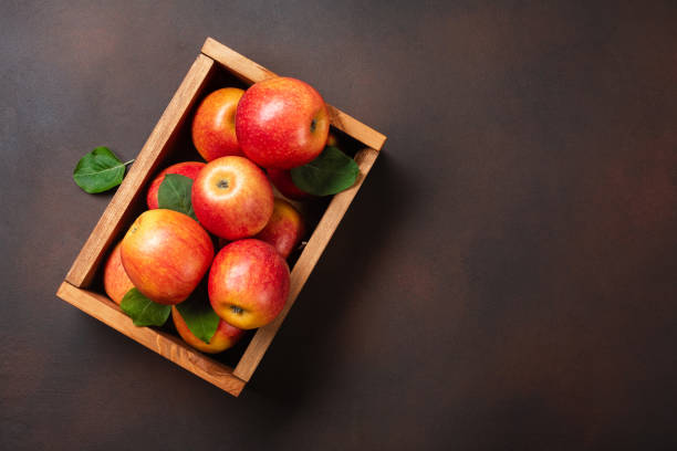 istock Ripe red apples in wooden box on a rusty background 1328507703