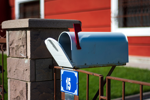 Just in front of the garden gate is an old-style mailbox with an open lid. Selective Focus Mail Box