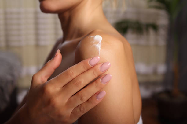 istock Attractive woman applying white cream on shoulder after bathing 1328510398