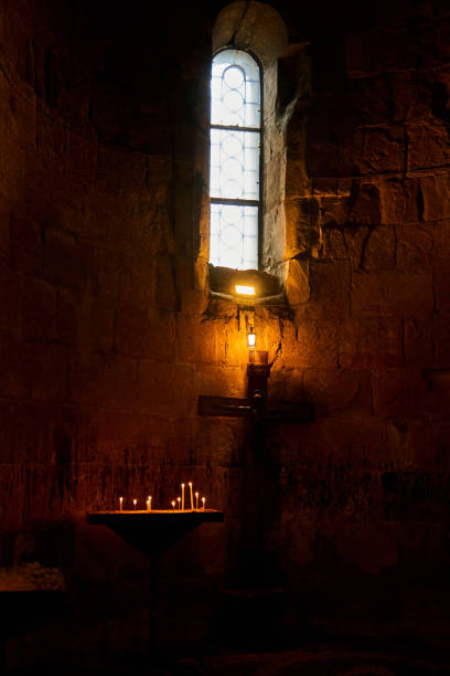 istock Dark temple with small windows and burning candles 1328510424