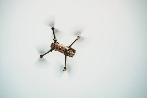 From below view of drone quadcopter with camera flying - Technology and spying concept