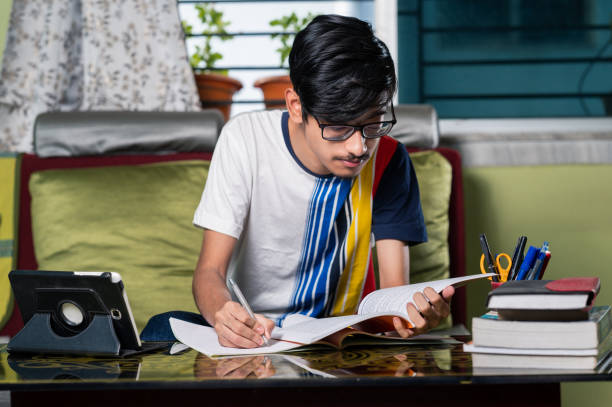 istock Young boy studying at home using digital tablet and Mobile phone. 1328511479
