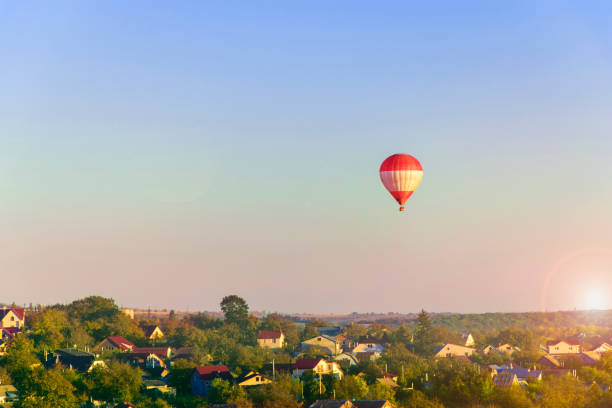 istock Hot air balloon flying over city on the sunset 1328512962