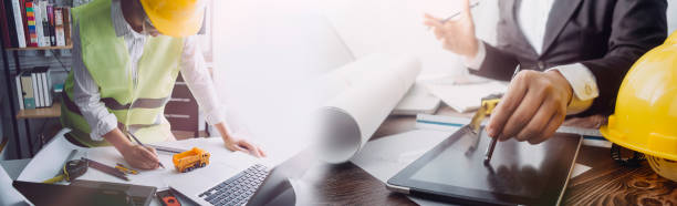 istock engineer working at a drawings of house in office for discussing. Engineering tools and construction concept. 1328513529