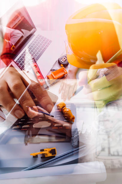 istock engineer working at a drawings of house in office for discussing. Engineering tools and construction concept. 1328513714