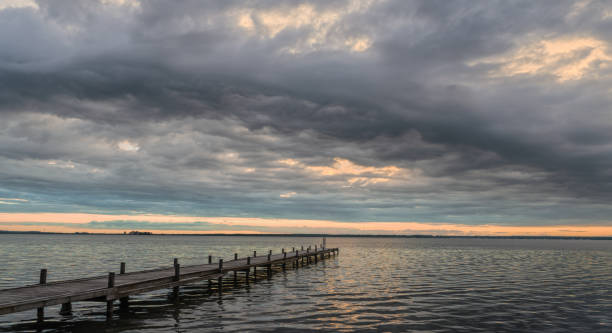 istock Spectacular cloudscape over lake and jetty at dusk 1328514488