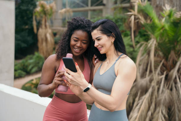 istock Girlfriends in sportswear using smartphone. 1328516558