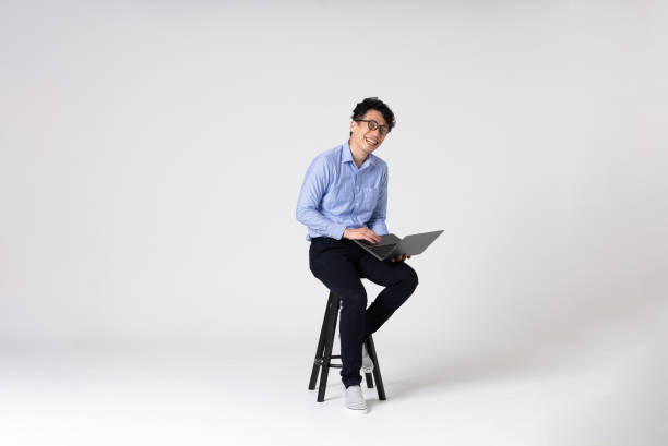 Full-length portrait of an Asian man on a white background. Full-length portrait of an Asian man on a white background.
Full body shot. Japanese male, 30s.
Healthy and confident figure.
sitting on a chair. one mid adult man only stock pictures, royalty-free photos & images