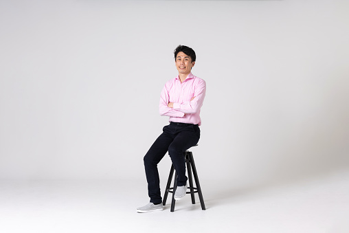 Full-length portrait of an Asian man on a white background.
Full body shot. Japanese male, 30s.
Healthy and confident figure.
sitting on a chair. smiling.