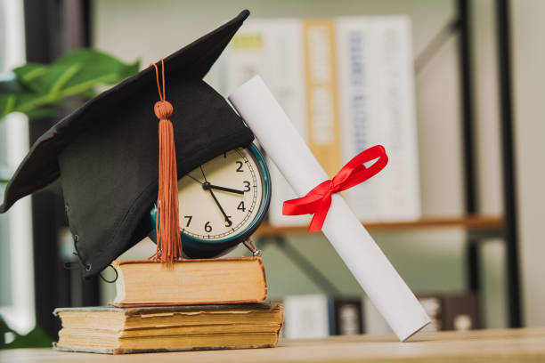 istock graduation cap and book with clock on wood table background 1328521364