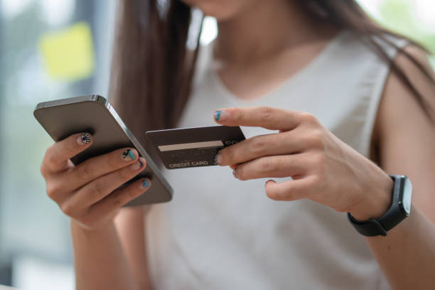 istock Hands holding credit card and using mobile smart phone with morning, Online shopping. 1328521633