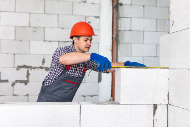 istock The bricklayer measures a newly built wall with a tape measure 1328522737