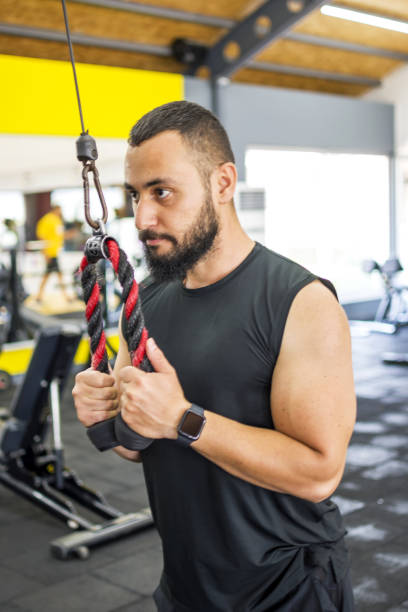 istock Muscular bodybuilder guy doing exercises in gym 1328522797