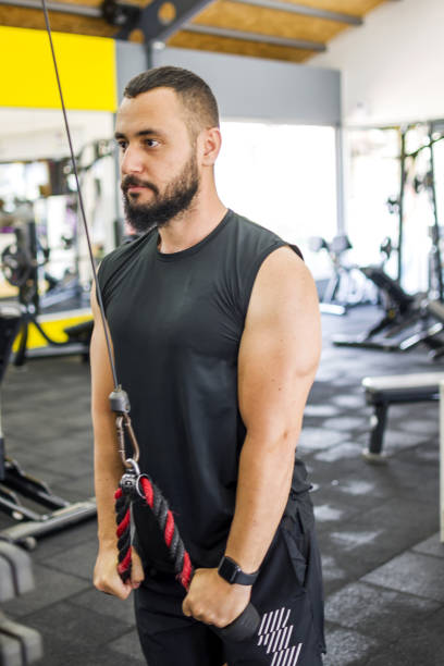 istock Muscular bodybuilder guy doing exercises in gym 1328523694