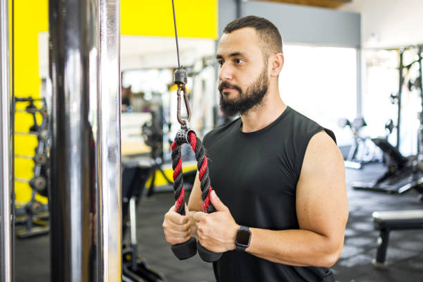 istock Muscular bodybuilder guy doing exercises in gym 1328523939