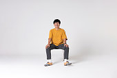 Full-length portrait of an Asian man on a white background.